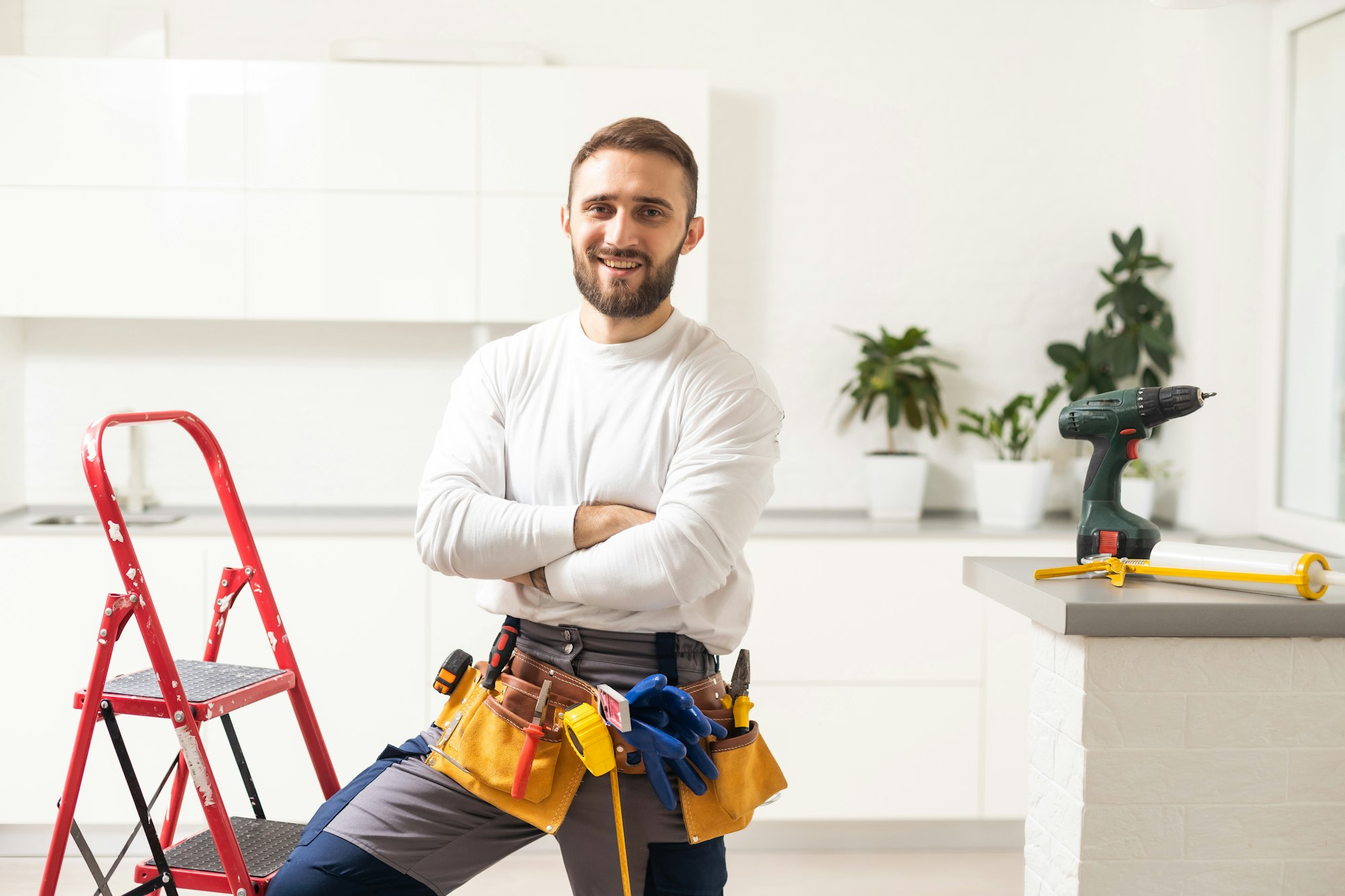 Male Worker Sitting on the Ladder on Construction Site. Repair Home and House Renovation Service